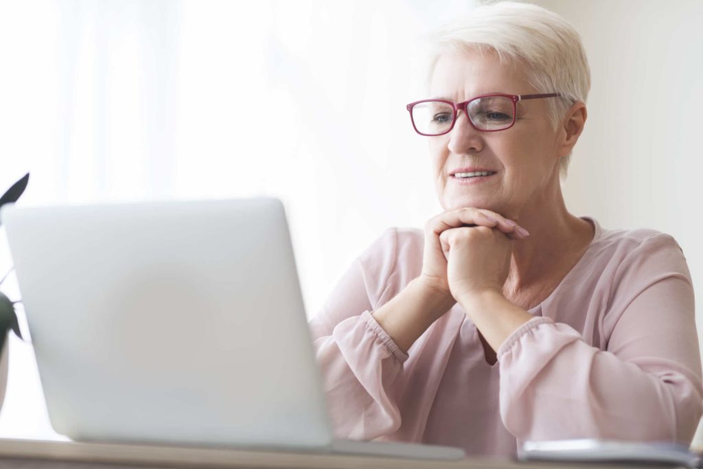 Äldre kvinna framför datorn